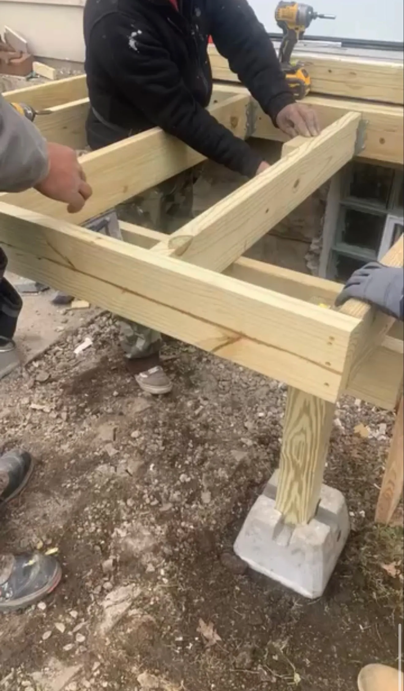Osas crew framing a raised wooden deck on concrete footings