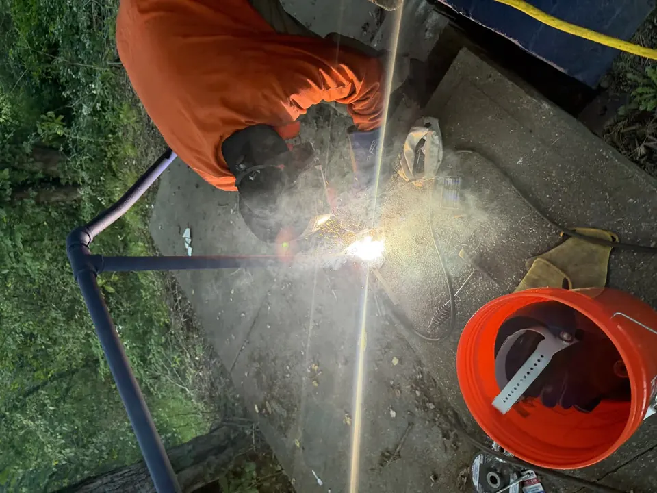 Metal handrail welding repair beside a concrete walkway