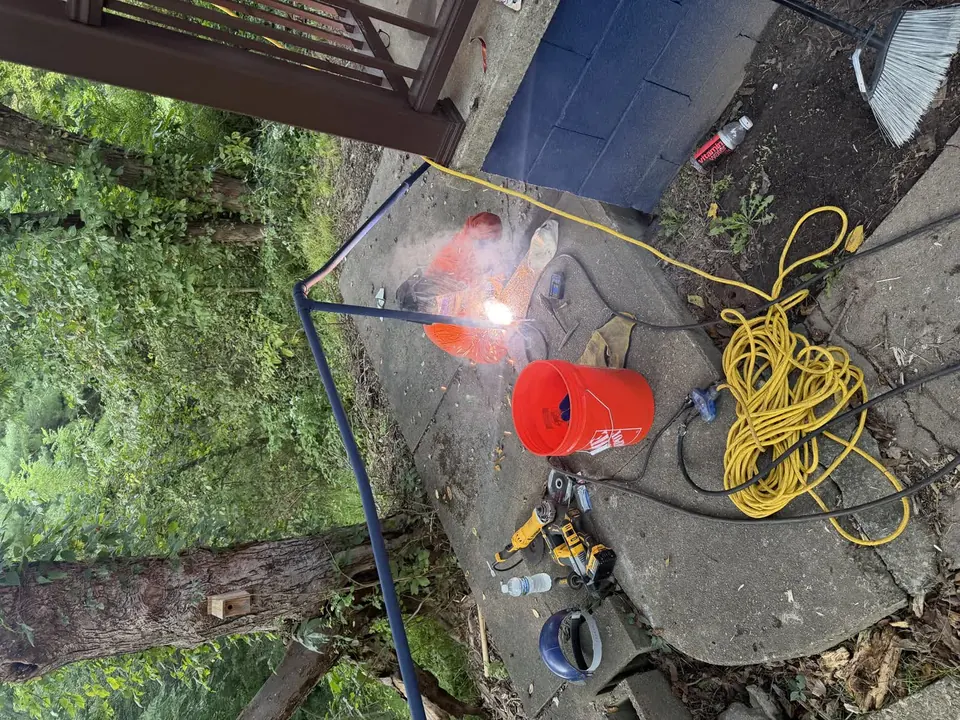 Metal handrail welding repair beside a concrete walkway