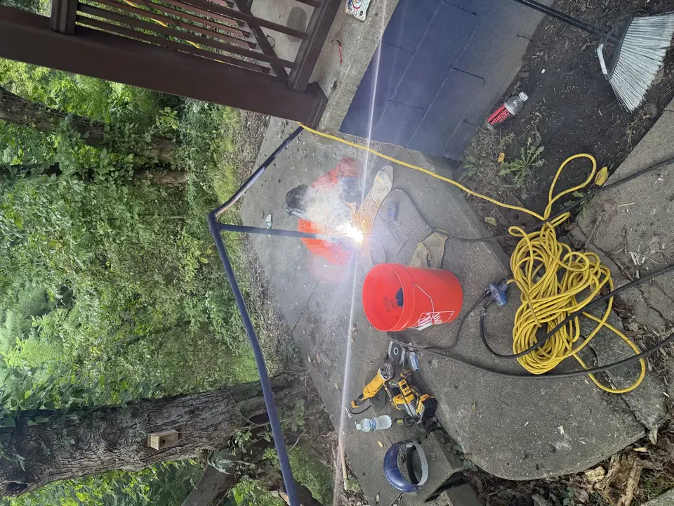 Metal handrail welding repair beside a concrete walkway