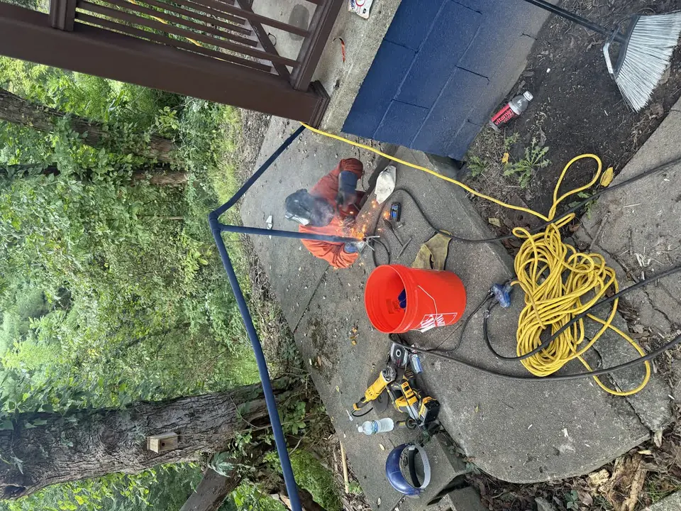Metal handrail welding repair beside a concrete walkway