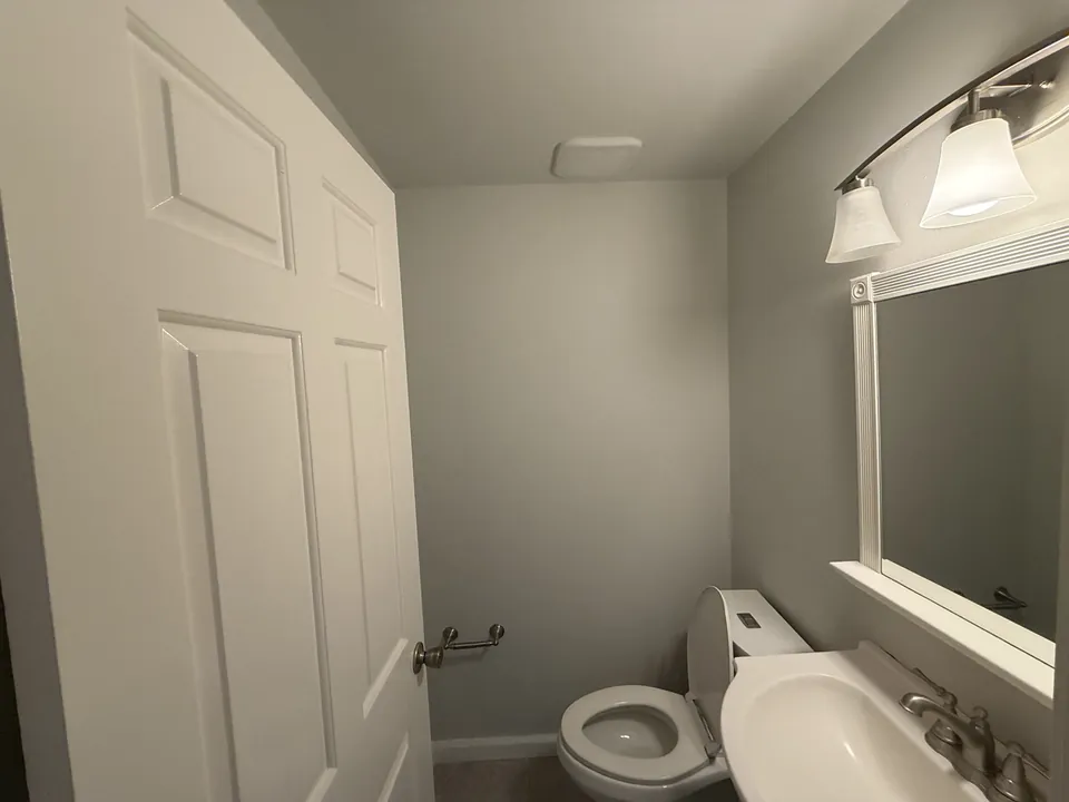 Bathroom vanity, mirror, and toilet
